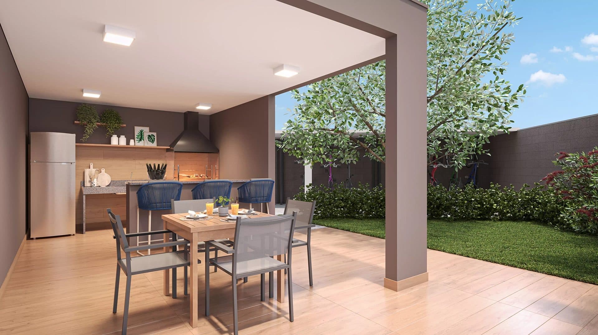 Área gourmet externa com churrasqueira, bancada, mesa de jantar e jardim.