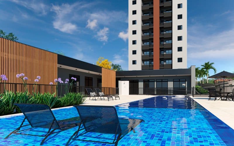Piscina externa com espreguiçadeiras e vista para o edifício.