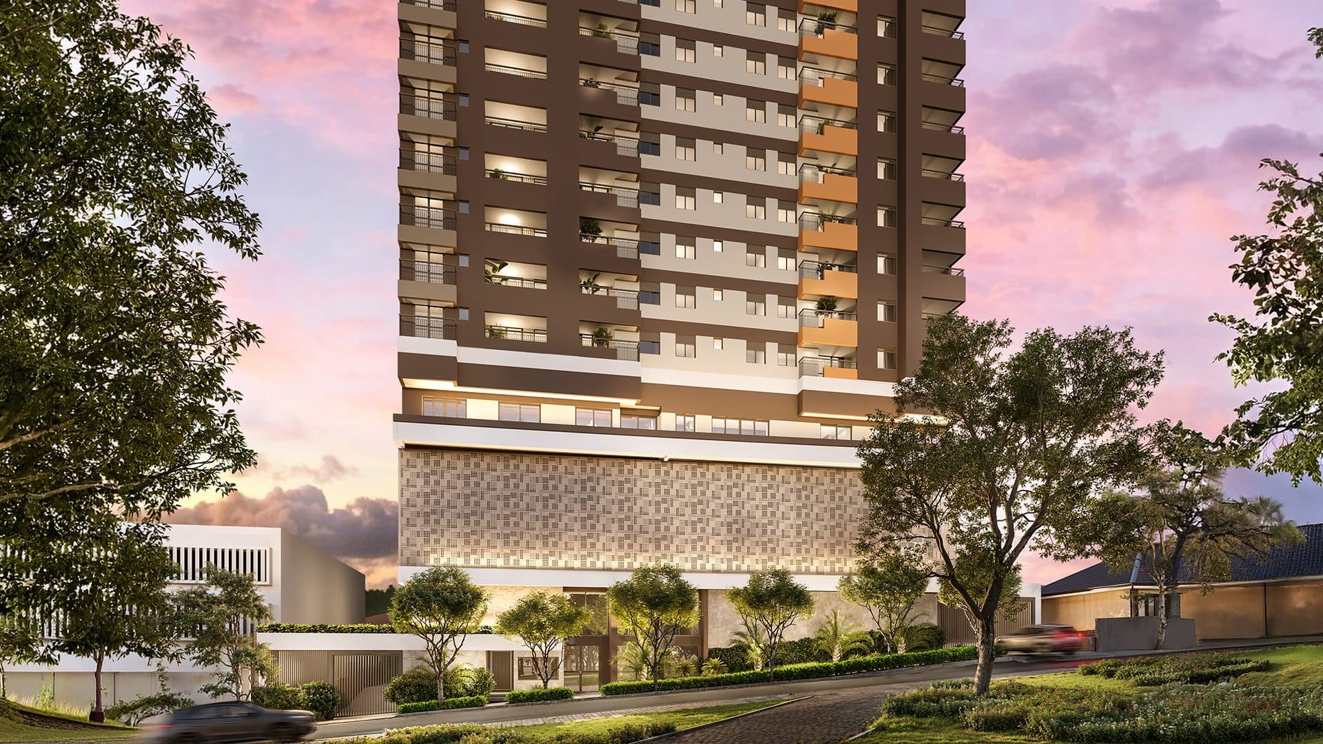Perspectiva externa do edifício residencial com paisagismo e céu ao entardecer.